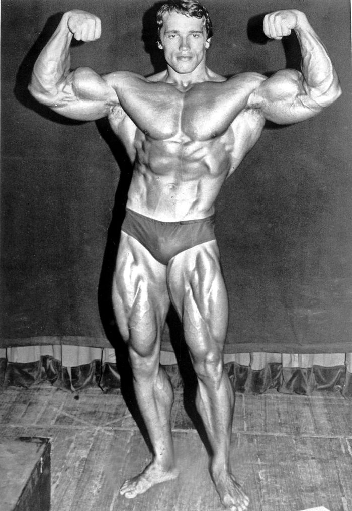 Arnold Schwarzenegger in a front double biceps pose, 1974, black and white press photograph